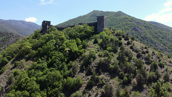Tvrđava Maglič okružena zelenim planinama u Srbiji.	