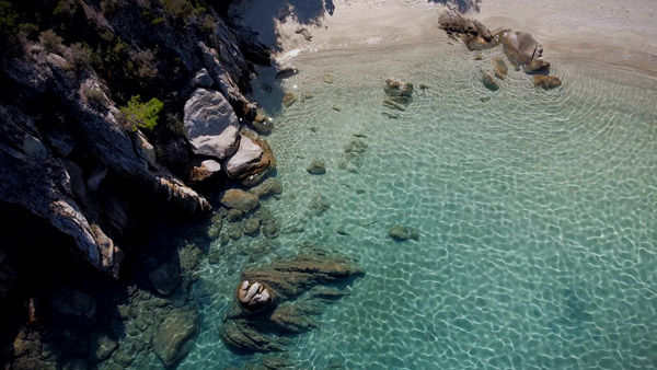 Rajska plaža na Sitoniji sa tirkiznim morem, belim peskom i prirodnim okruženjem.